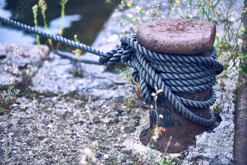 Noray with rope at pier of harbor