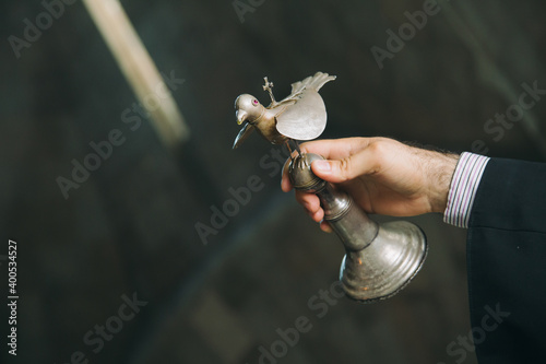 Tablou Canvas Armenian priest in monastery holding a bird made of silver during christening ri