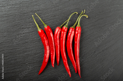 Red chile peppers on a black slate board. Spicy food concept. Space for text.