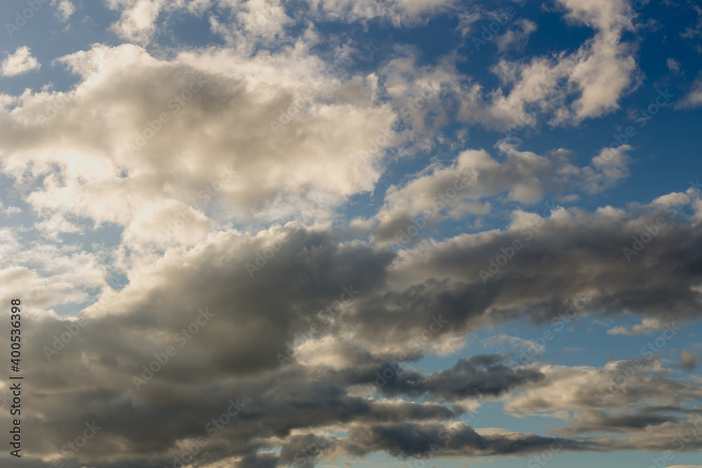 Background. A blue sky with white, airy, cumulus clouds.