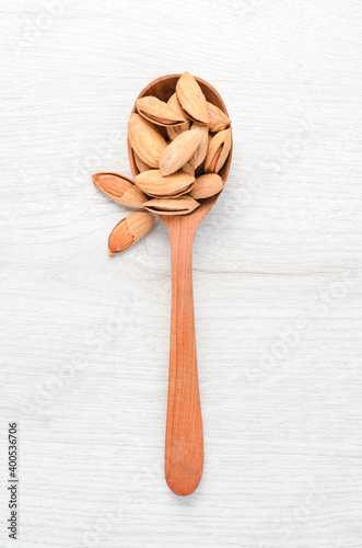Almond nut in a wooden spoon. Top view. Free space for your text.