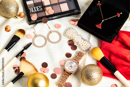 Christmas or new year eve background. Jewelry and makeup presents with neklace, makeup brush, earrings.