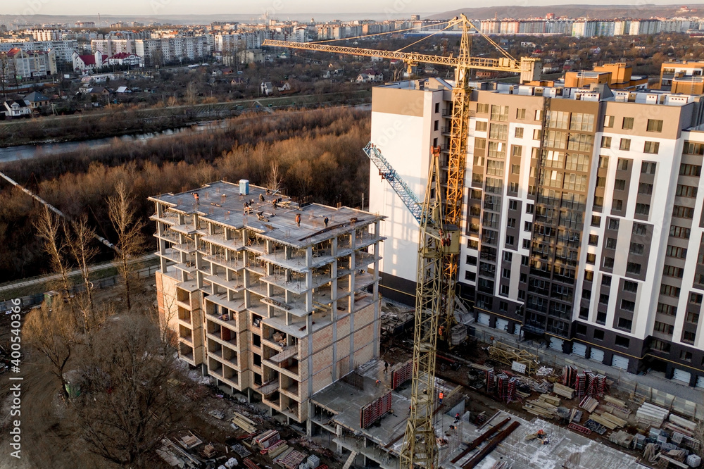Fototapeta premium Construction and construction of high-rise buildings, the construction industry with working equipment and workers. View from above, from above. Background and texture