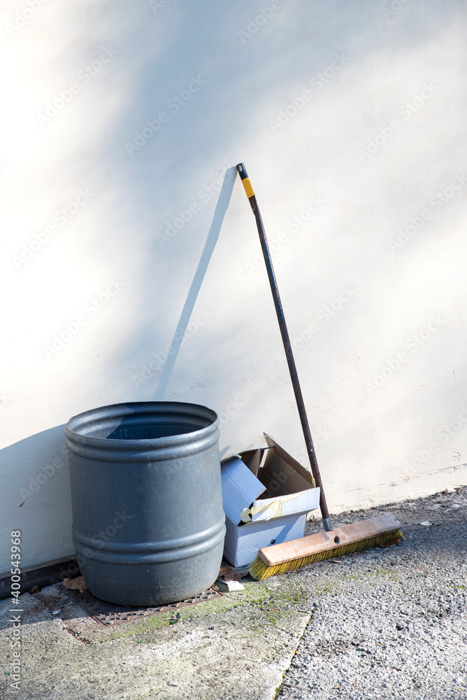 broom and garbage can on the street broom and garbage can on the street