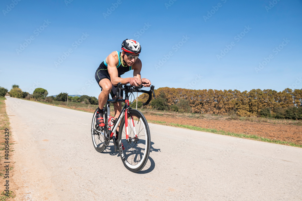 Fototapeta premium Cyclist with helmet and sunglasses riding in a rural path