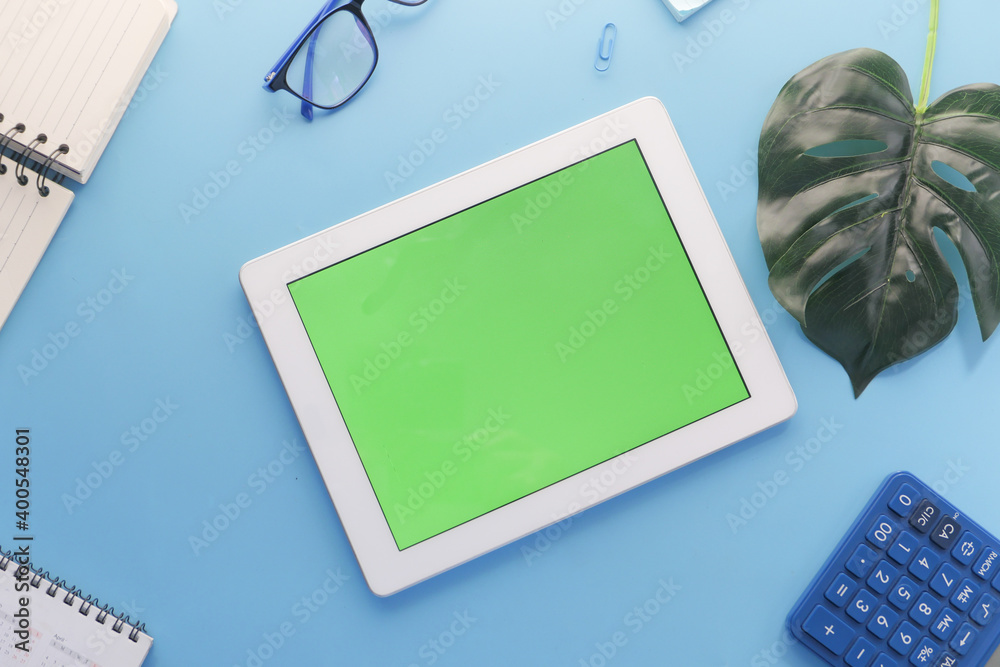 top view of digital tablet with office suppliers on blue background top view of digital tablet with office suppliers on blue background