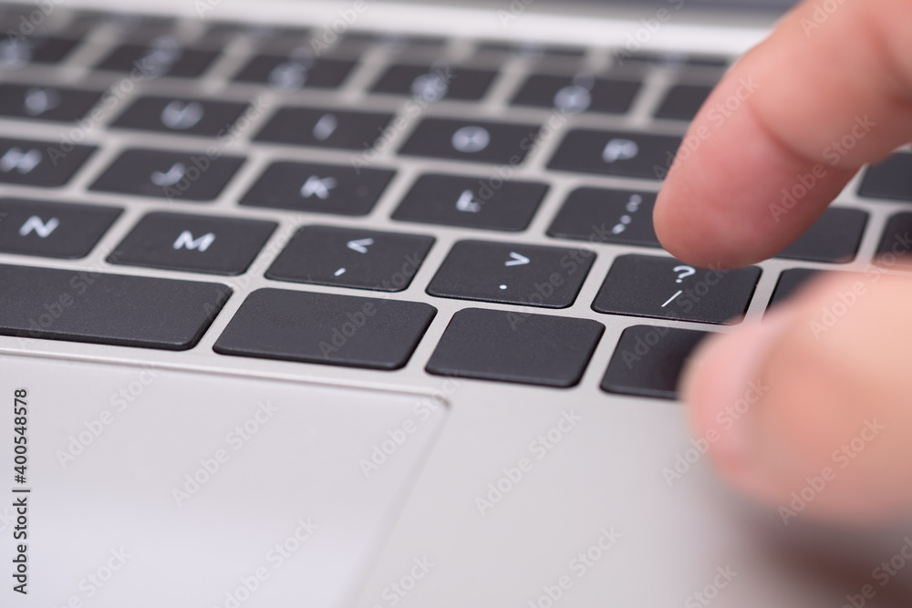 Close up fingers on buttons question marks texts on a laptop computer, or typing hands the keyboard Close up fingers on buttons question marks texts on a laptop computer, or typing hands the keyboard