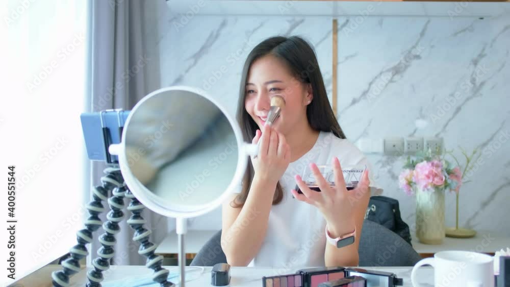Portrait of young asian woman review cosmetics prosduct fan following channel, recording video make up lipstic cosmetic at home. Beauty blogger present beauty cosmetics. Portrait of young asian woman review cosmetics prosduct fan following channel, recording video make up lipstic cosmetic at home. Beauty blogger present beauty cosmetics.