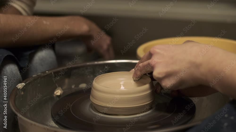 The process of preparing tableware from natural clay on a potter's machine The process of preparing tableware from natural clay on a potter's machine