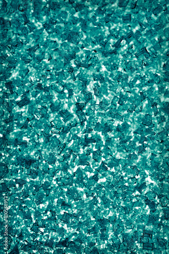 Dark blue green winter background. Abstract vertical wallpaper. Ice crystals on the window pane close up. Turquoise or cyan tinted backdrop with vignetting frame. Macro