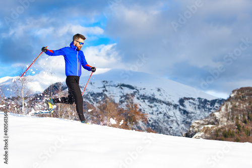 A man running downhill with snowshoes