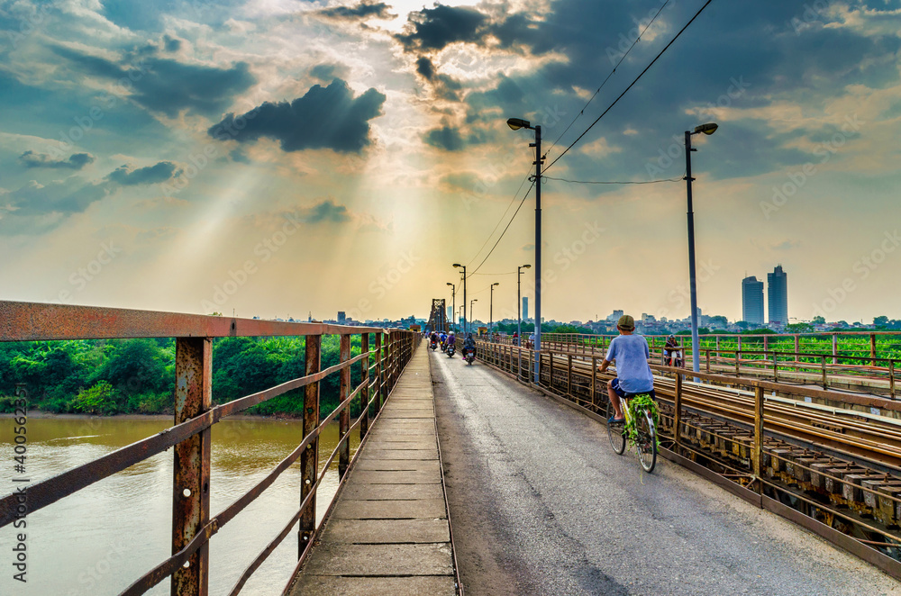 A man rides a bicycle on the Long Bien Bridge in Vietnam  on a picturesque day