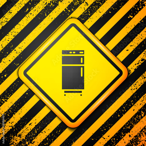 Black Refrigerator icon isolated on yellow background. Fridge freezer refrigerator. Household tech and appliances. Warning sign. Vector.