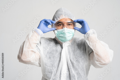 asian man preparing to wear a personal protective equipment suit in white background