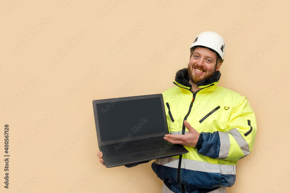 Male industrial worker in hard hat with laptop. Bearded engineer with white hard hat helmet working on laptop computer. Climber Male industrial worker in hard hat with laptop. Bearded engineer with white hard hat helmet working on laptop computer. Climber