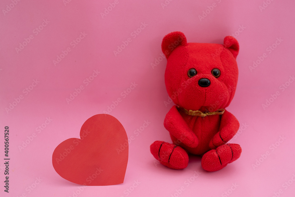 Composition in red on a pink background. Toy bear and heart Composition in red on a pink background. Toy bear and heart