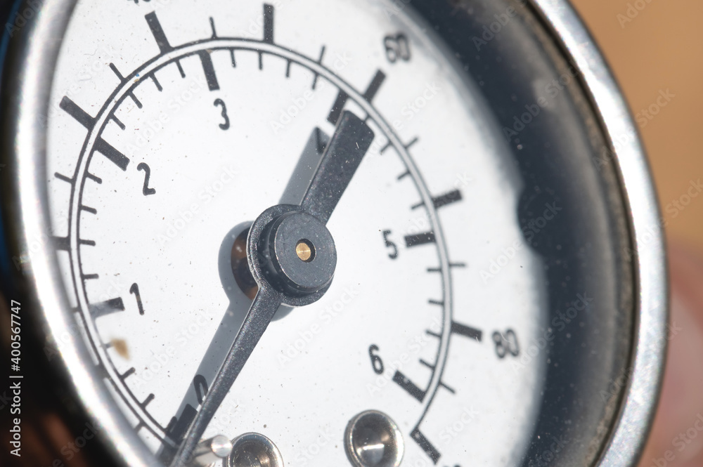 Close-up of an old industrial pressure gauge display with worn protective glass. Macro Close-up of an old industrial pressure gauge display with worn protective glass. Macro