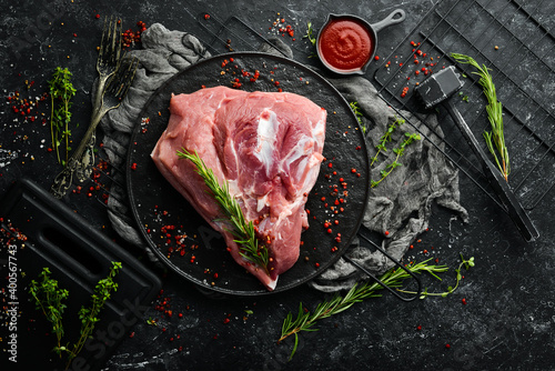 fresh raw pork shoulder with ingredients and spices on kitchen background. Meat. Top view. Rustic style. photo