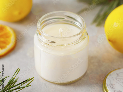 Aroma candle with scent of citrus. New Year's atmosphere. Aromatherapy photo with citrus fruits. horizontal orientation. candle with the aroma of lemon, citrus. New Year's mood. Aromatherapy.