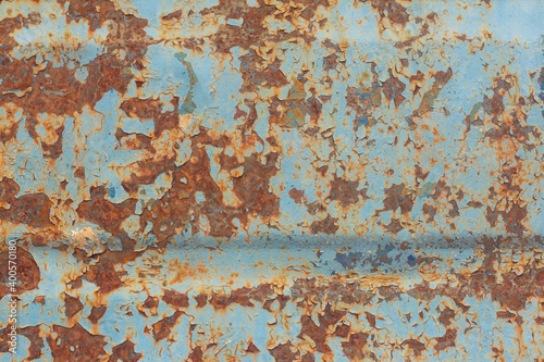 Brown and orange rust on old blue metal.