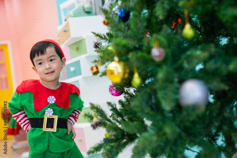 Merry Christmas A boy decorating a christmas tree Merry Christmas A boy decorating a christmas tree