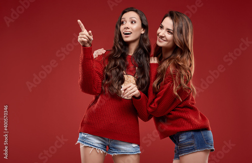 crazy sisters best friends twins in fashion cozy winter sweater in studio