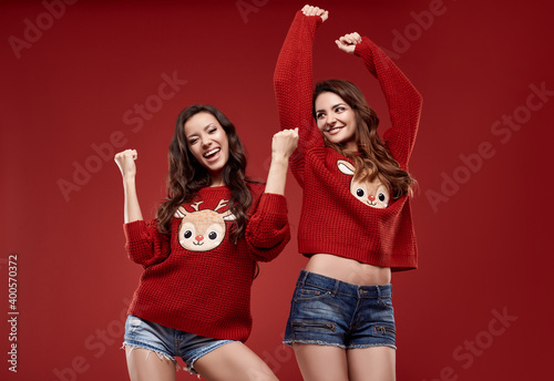 crazy sisters best friends twins in fashion cozy winter sweater in studio