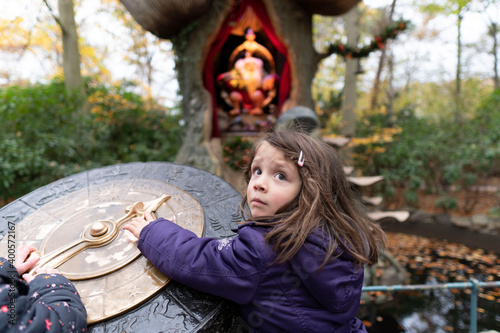 The little girl looks a little scared in the fairytale playground.