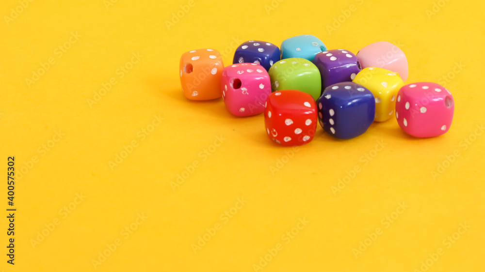 Small dice of various colors on yellow background. Small dice of various colors on yellow background.