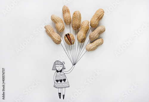 Cartoon of a girl holding real peanuts in her hand like balloons