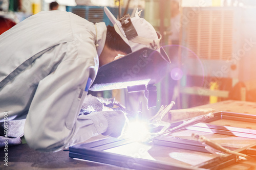 Industrial worker in manufacturing plant grinding to finish a Metal pipe,Industrial Worker at the factory welding closeup