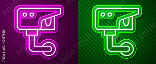 Glowing neon line Security camera icon isolated on purple and green background. Vector.