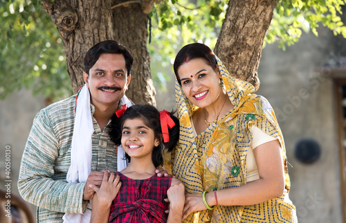 Rural Indian family with daughter looking at camera