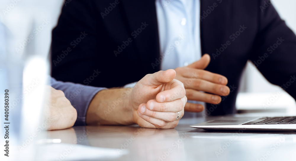 Business people using laptop computer while working together at the desk in modern office. Unknown businessman or male entrepreneur with colleague at workplace. Teamwork and partnership concept Business people using laptop computer while working together at the desk in modern office. Unknown businessman or male entrepreneur with colleague at workplace. Teamwork and partnership concept