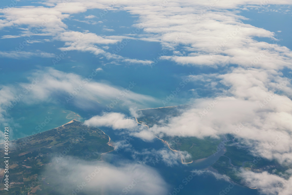 Aerial view from plane of cloud over island and sea Aerial view from plane of cloud over island and sea