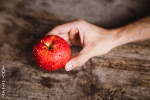 Mano che tiene una mela rossa biologica photo