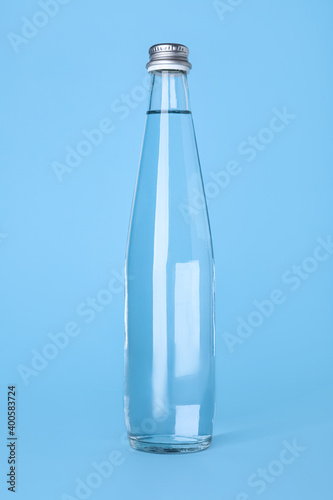Wallpaper Mural Glass bottle with water on light blue background Torontodigital.ca