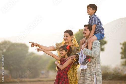 Happy rural Indian family on agricultural field