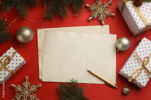 Flat lay composition with blank sheets of paper on red background, space for text. Writing letter to Santa