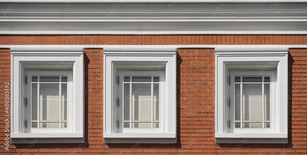 Window on background of brick wall of residential building.