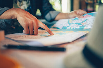 Close-up Tourist planning vacation with map and other travel accessories on the table. Travel, holiday, vocation concept.