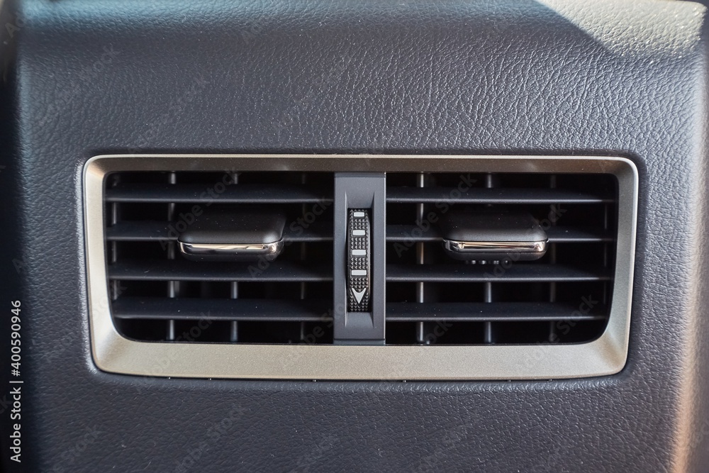 Car air vents providing airflow for backseat passengers