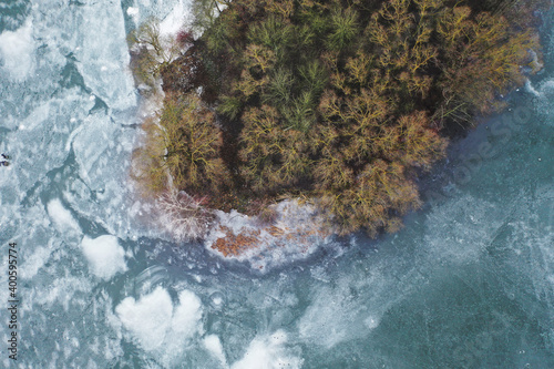 top view of an island in the middle of a frozen lake and fishermen catching fish