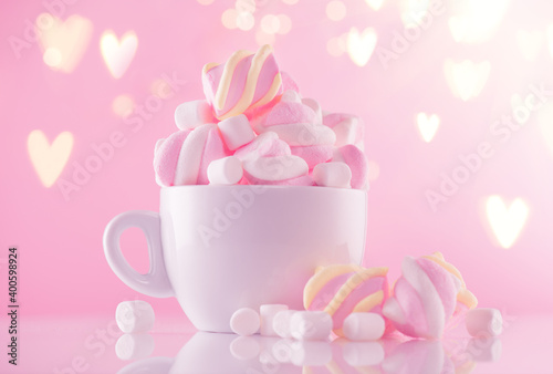 Marshmallow. Close-up of Marshmallows colorful chewy candy, over pink bokeh background, closeup. Sweet holiday food dessert in a cup with hot chocolate close-up. Candies. 