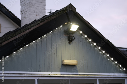 Roof top of the house with installed illumination. The large flood light and small decorative lights. photo