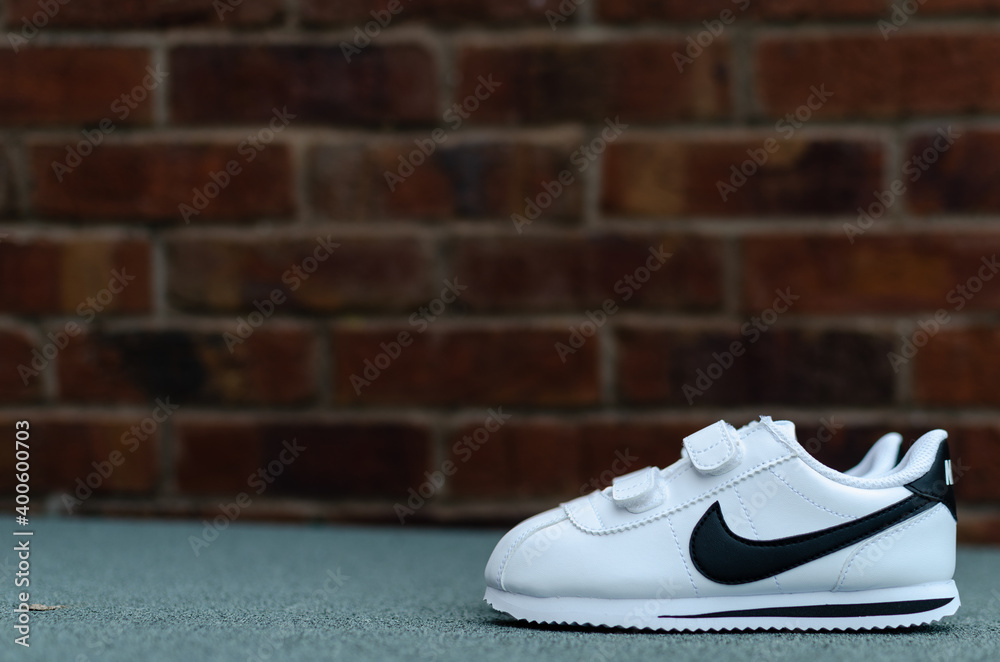 Stone, Staffordshire / United Kingdom - May 15, 2019: The close up photo of  child's pair of white Nike trainers. The brick wall is on the background.  foto de Stock | Adobe Stock