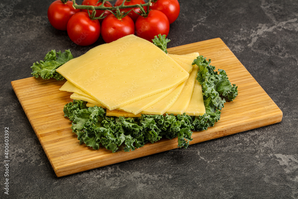 Sliced Gauda cheese over board Sliced Gauda cheese over board