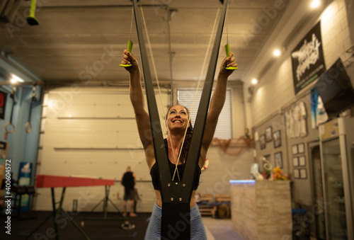 mujer contenta haciendo dorsales en un gimnasio 