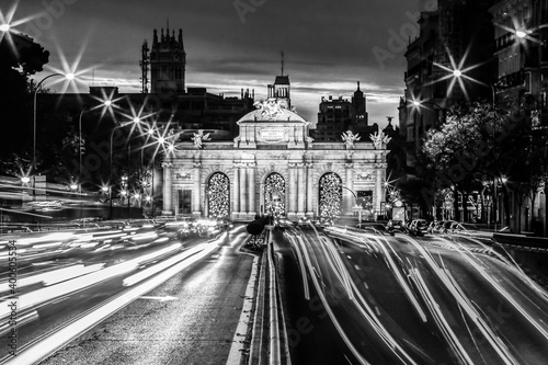 Night photo of Puerta de Alcala, neo-classical monument in the Plaza de la Independencia in Madrid, Spain in black and white.