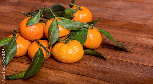 fresh tangerines with leaves on a wooden background